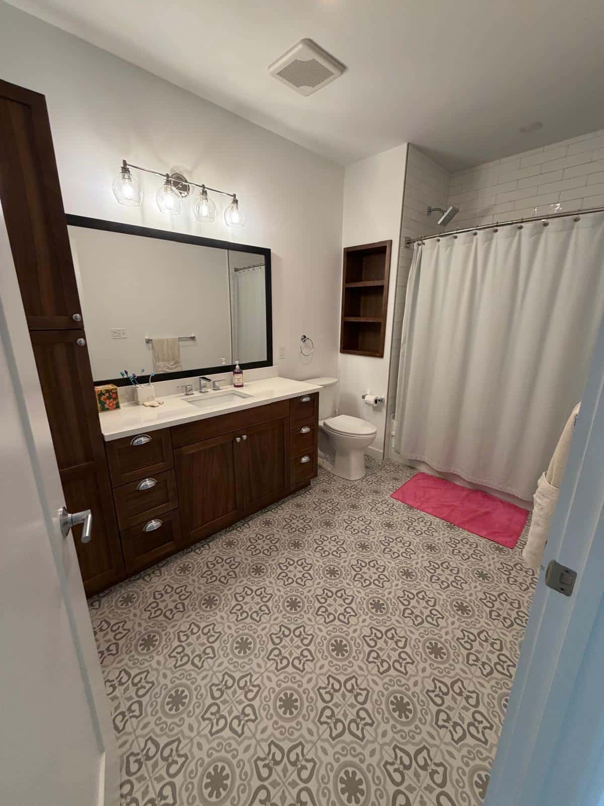 Bathroom with patterned cement tile floor and a wood vanity after cleaning