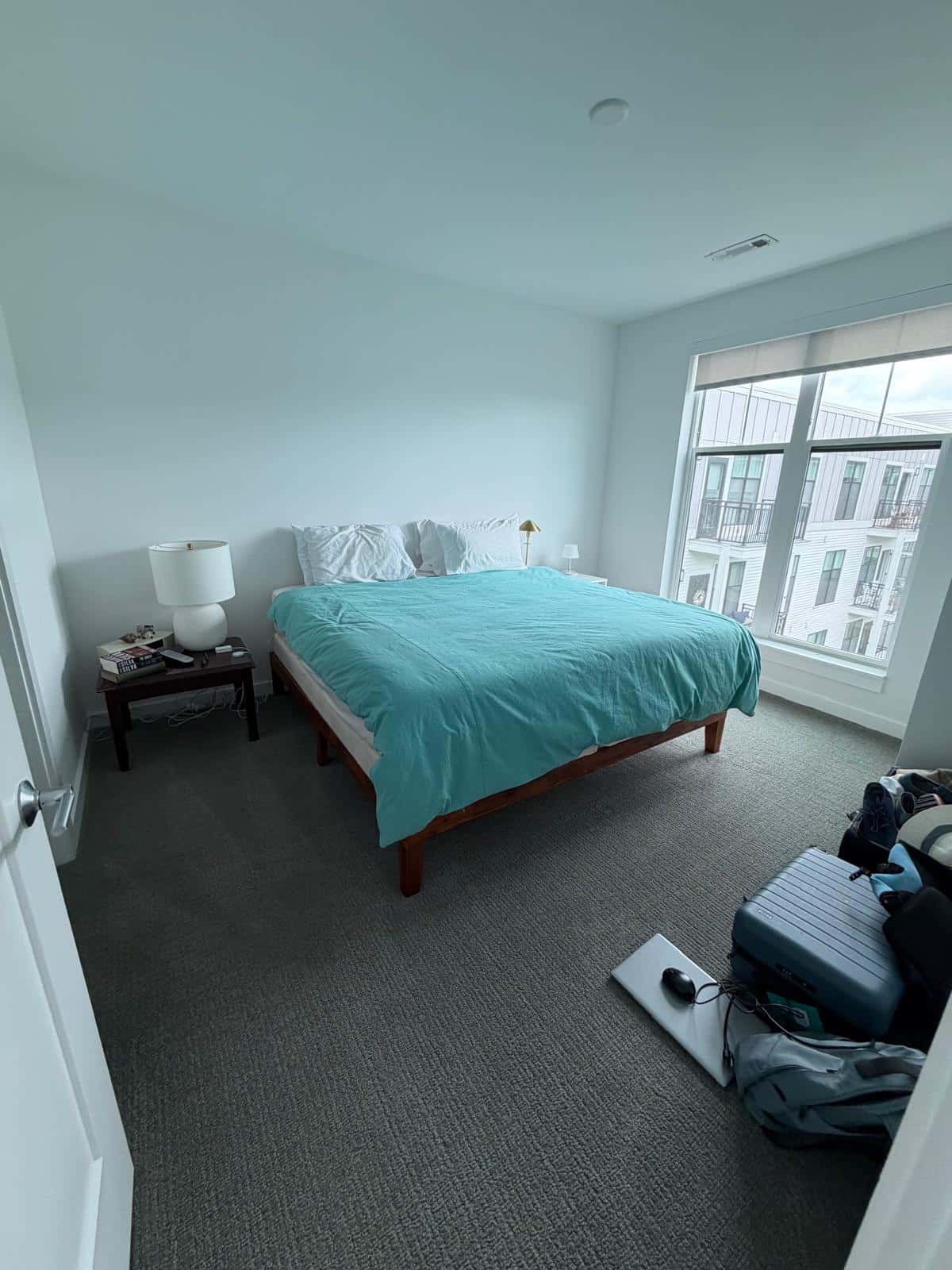 Condo bedroom with carpet vacuumed and bed made after a cleaning visit