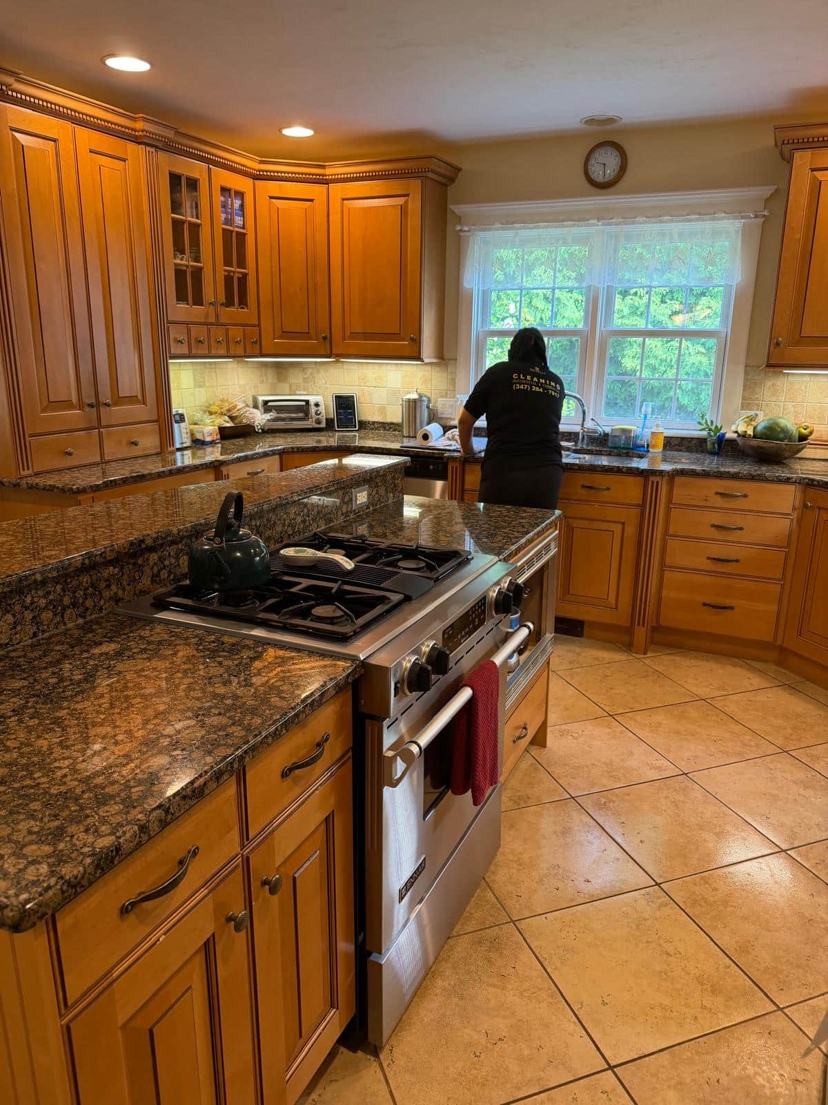 A Global Facility Service team member in uniform cleaning a client's kitchen