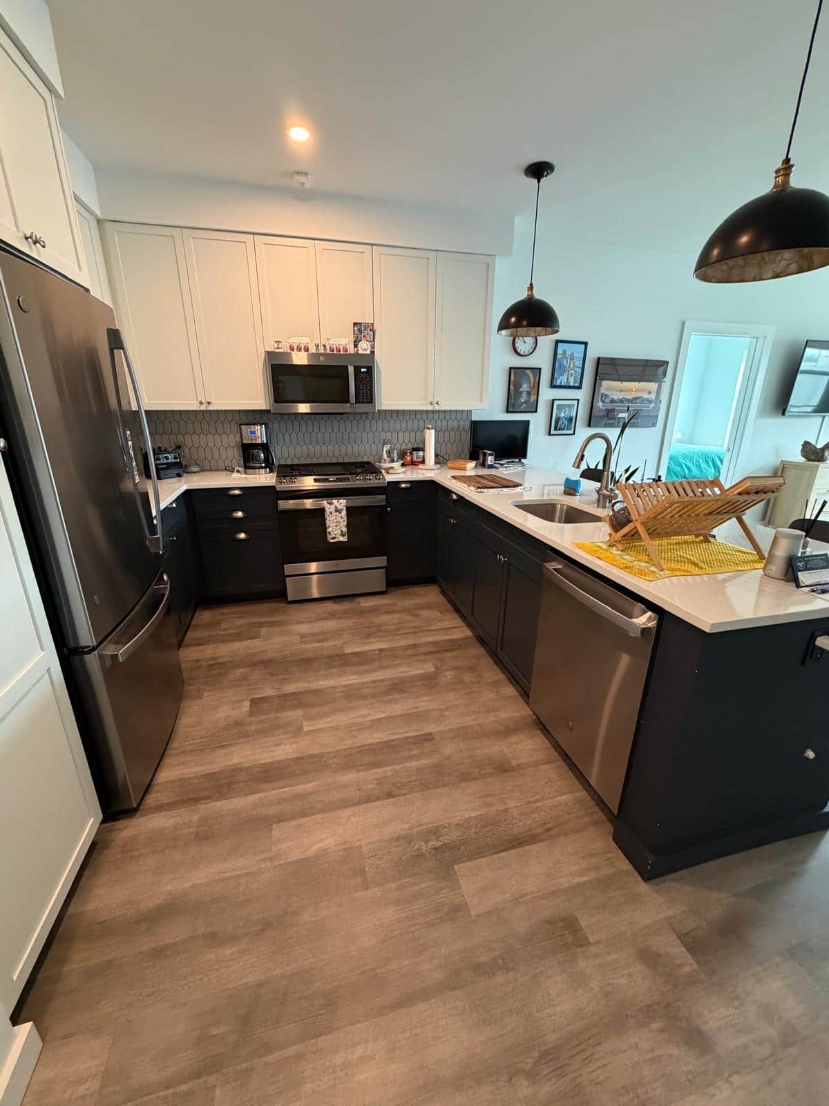 Modern condo kitchen with white quartz counters and dark cabinets after cleaning