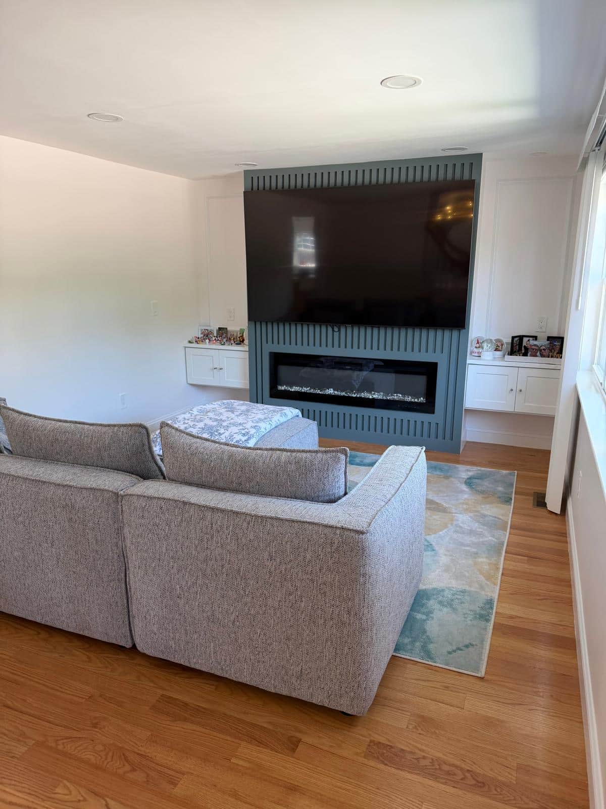 Family room with a fluted fireplace surround and a sectional sofa after cleaning