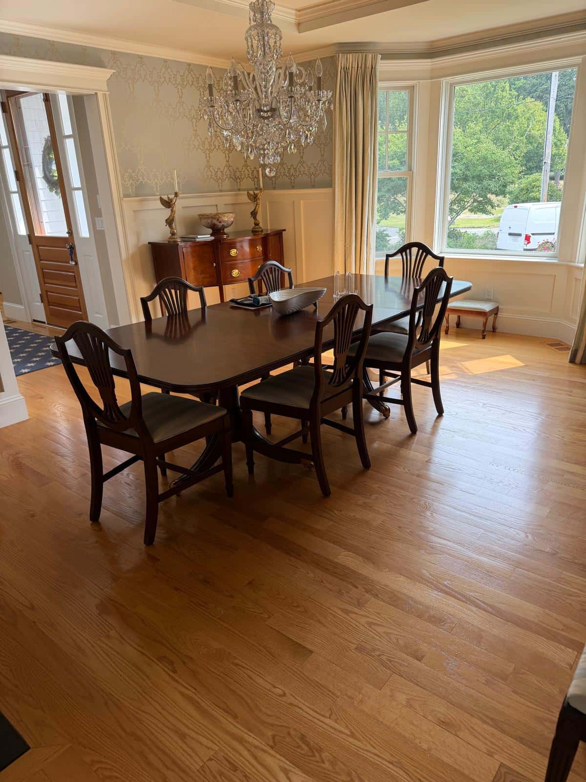 Dining room with chandelier and polished hardwood floor after a recurring house cleaning visit