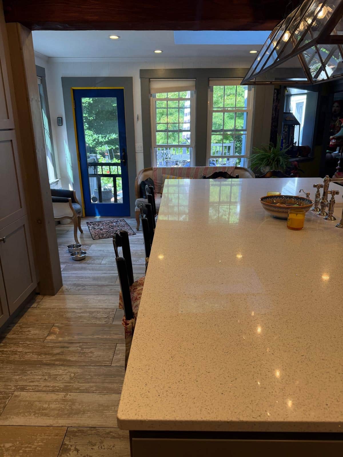 Open plan kitchen with quartz island and tile floor after cleaning