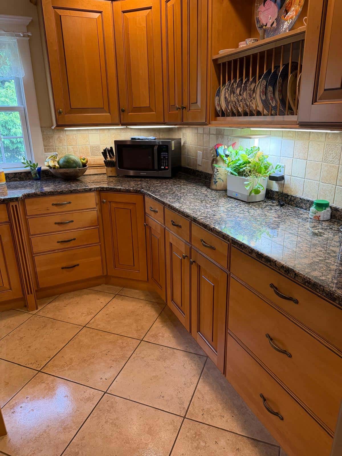 Granite counters and wood cabinet fronts cleaned along a kitchen wall