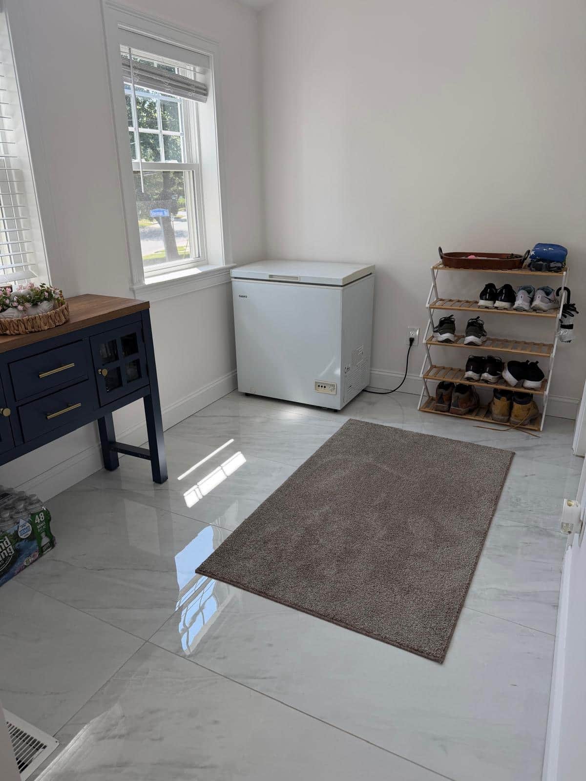 Mudroom with marble floor, shoe rack and freezer after a cleaning visit