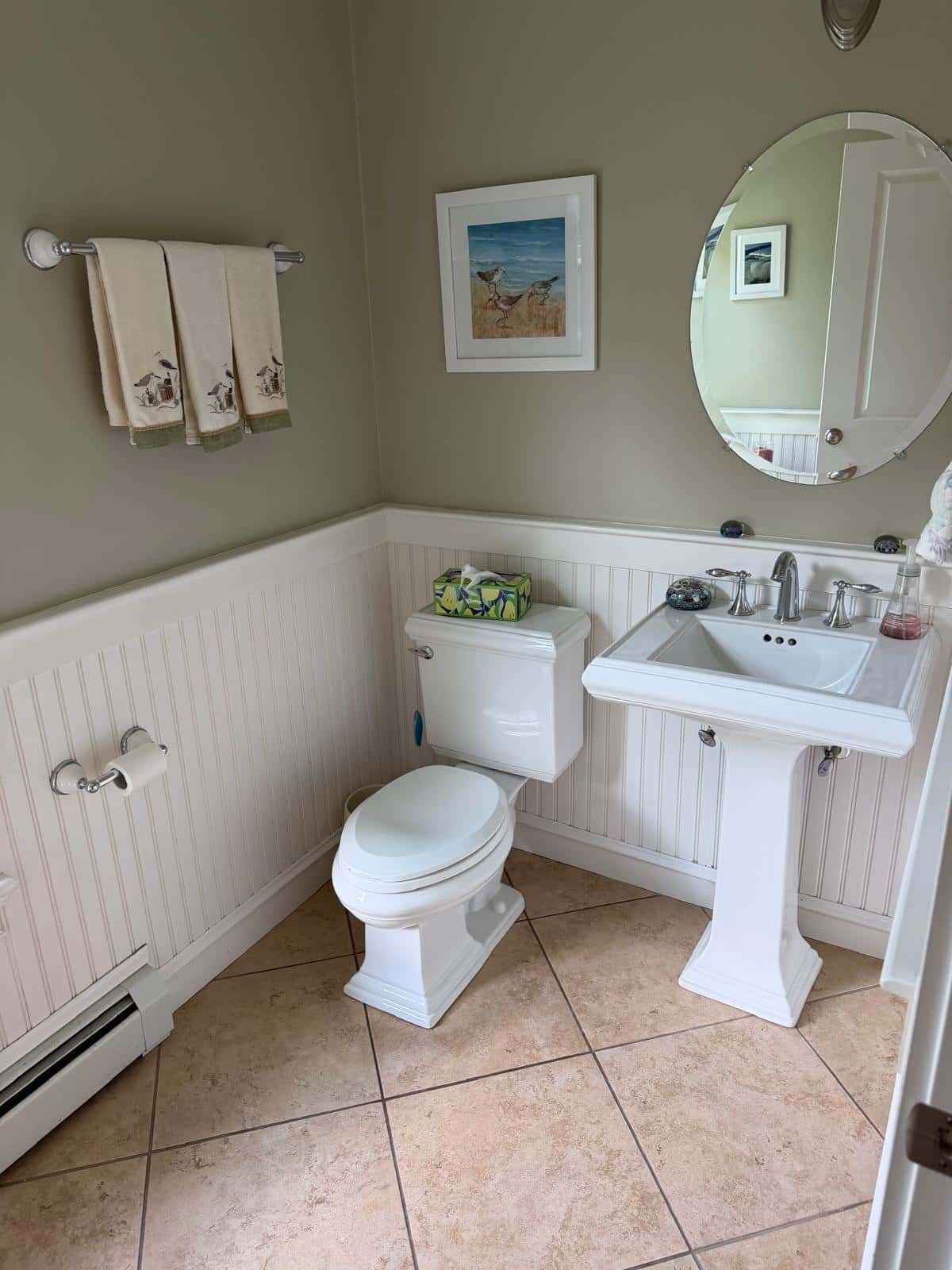 Powder room with pedestal sink, beadboard wainscoting and tile floor after cleaning